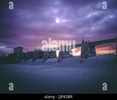 Un ponte di cemento con pareti di graffiti arti durante un bellissimo tramonto Foto Stock