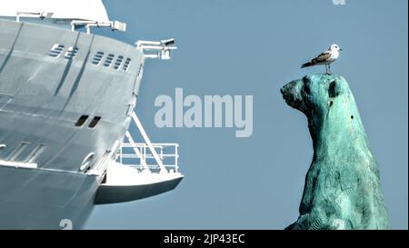 Un gabbiano sulla testa di una statua di bronzo dell'orso polare di fronte ad una nave in Danimarca Foto Stock