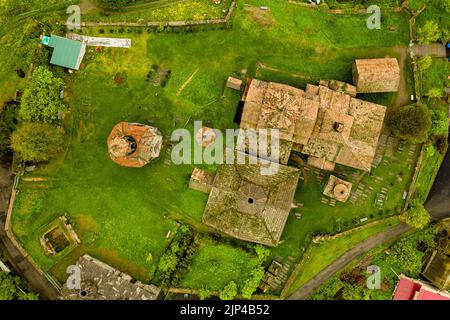 An aerial view of Haghpat monastery on top of a green hill full of houses in Armenia Stock Photo