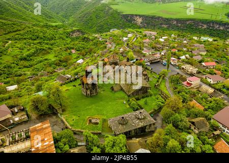 Una vista aerea del monastero di Haghpat sulla cima di una collina verde piena di case in Armenia Foto Stock