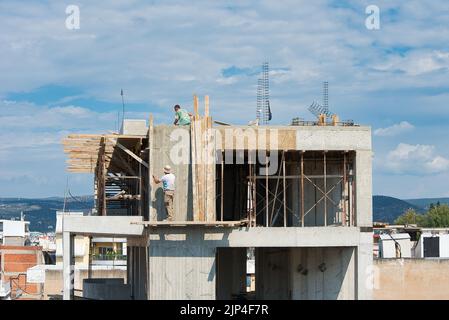 cantiere, operai edili in lavori pericolosi, per la costruzione di un edificio a più piani Foto Stock