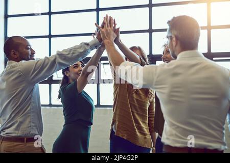 Il team di allegri colleghi festeggia con cinque persone dopo aver ascoltato le buone notizie in ufficio. Squadra diversa che vince e si sostiene l'un l'altro Foto Stock