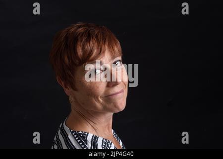 ritratto di mezza età che attiva lo sfondo nero Foto Stock