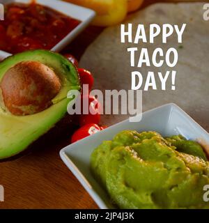 Composizione del testo Happy taco Day con taco ingedients sul tavolo. Giornata nazionale del taco e concetto di celebrazione immagine generata digitalmente. Foto Stock