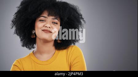 Un aspetto luminoso e positivo. Studio di una giovane donna attraente che posa su uno sfondo grigio. Foto Stock