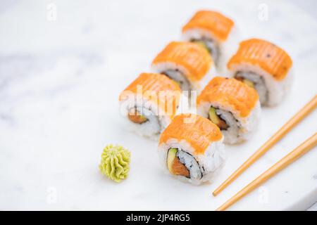 Panini sushi su piatto, sfondo luminoso. Servito con wasabi e zenzero. Sushi giapponese assortito. Cibo tradizionale. Foto Stock