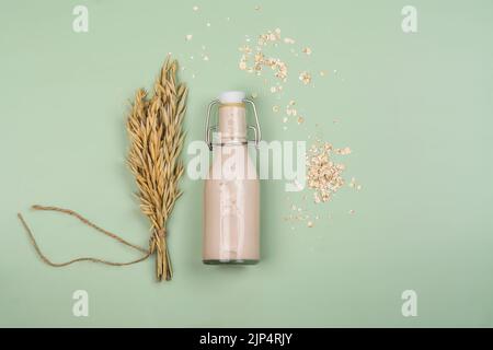 A base vegetale, latte privo di lattosio. Latte di avena fatto in casa con ingredienti su sfondo di legno. Giornata mondiale del latte vegetale. Spazio di copia Foto Stock