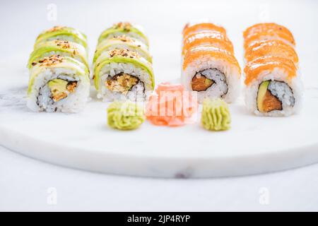 Panini sushi su piatto, sfondo luminoso. Servito con wasabi e zenzero. Sushi giapponese assortito. Cibo tradizionale. Foto Stock