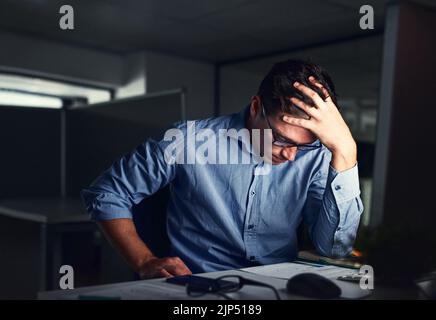 Stressato, uomo d'affari stanco che soffre di mal di testa, lavorando a tarda notte in ufficio. Preoccupato imprenditore maschio pensare a problemi e progetto Foto Stock