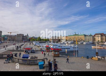 Bella vista di persone e barche sul molo nel centro di Stoccolma in giornata intensa. Svezia. Stoccolma. Foto Stock