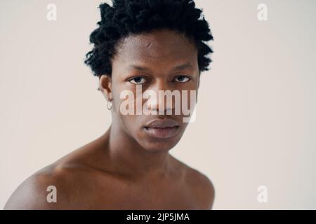 silhouette di un uomo africano muscoloso che si posa in uno studio fotografico su sfondo bianco senza un ritratto da vicino della t-shirt Foto Stock