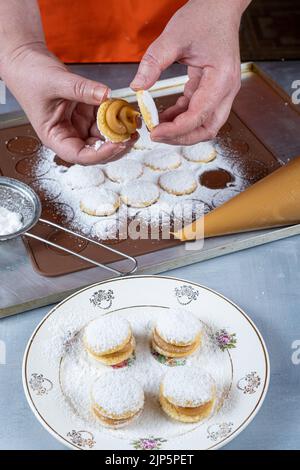 Pasticciere finendo il dolce di nozze dulce de leche con l'altra metà. Foto Stock