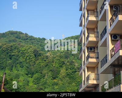 Balconi con vista sulle montagne. Hotel e attrazione sulla montagna. Vista dalla finestra dell'hotel alla croce sulla montagna. Georgia. Resort Place. H Foto Stock