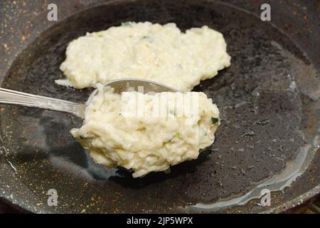 Ricetta per le frittelle di zucchine. Fase 4 - mettere l'impasto su una padella calda con olio. Frittelle vegetariane di verdure. Foto Stock