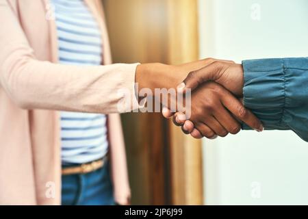 Grazie per il suo servizio di alto livello. Primo piano di un corriere che scuote le mani con un cliente mentre effettua una consegna. Foto Stock