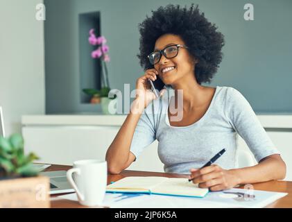 Grazie per avermi chiamato. Una giovane e attraente donna d'affari che lavora a casa. Foto Stock