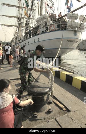 Un ufficiale militare che staccherà una corda di KRI Dewaruci (Dewa Ruci), una nave alta indonesiana, mentre sta creando una vela dopo che la goletta di tipo barquentino è stata aperta per i visitatori pubblici al porto di Kolinlamil (porto della Marina) a Tanjung Priok, nel nord di Giacarta, Jakarta, Indonesia. Foto Stock