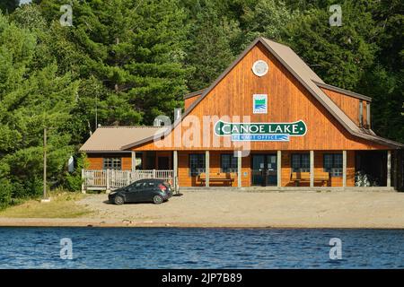 Algonquin Park, Ontario, Canada - 29 luglio 2022: L'Ontario Parks Permit Office al lago Canoe nel Parco Provinciale di Algonquin, visto dall'acqua. Foto Stock