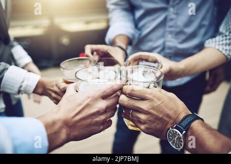 Heres al primo. Un gruppo di colleghi di lavoro irriconoscibili che hanno un brindisi celebrativo insieme con la birra fuori durante il giorno. Foto Stock
