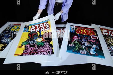 Foto non pubblicata in precedenza datata 02/08/22 di un dipendente Propstore in possesso di una stampa di un set di prova di sei stampe Star Wars 'Giclee' firmato da Stan Lee, 2015 (est. £5.000 - 7.000) durante un'anteprima per la loro prossima asta poster presso la loro casa d'aste a Rickmansworth, Hertfordshire. Data di emissione: Martedì 16 agosto 2022. Foto Stock