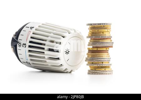 Testa della valvola termostatica con monete isolate su fondo bianco. Foto Stock