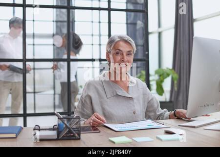 senior business donna grigio capelli tablet ufficio felice donna d'affari matura Foto Stock
