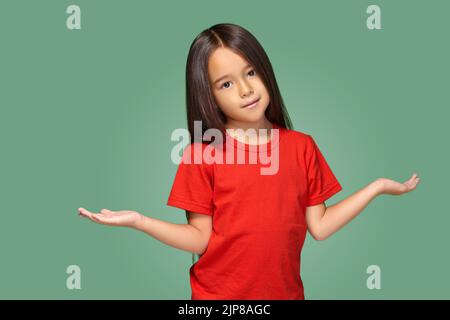 Ragazza sorpresa con braccia spalmato isolato su sfondo verde Foto Stock