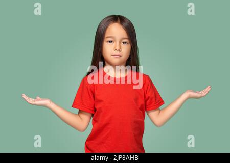 Ragazza sorpresa con braccia spalmato isolato su sfondo verde Foto Stock