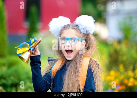 Ritratto di una giovane e bella Schoolgirl sullo sfondo la scuola. Addio Bell. Giorno della conoscenza. inizio dell anno scolastico. Foto Stock