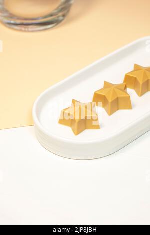 Cioccolato fatto a mano a forma di stella su un piatto bianco. Cioccolatieri fatti a mano. Foto Stock