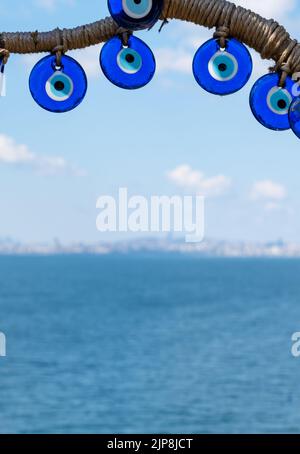 Perline di occhio malvagio primo piano su sfondo mare. Perle Nazar. Souvenir turistico turco Foto Stock