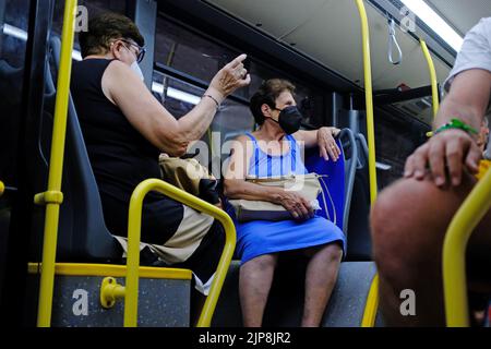 Italiani che viaggiano su un autobus con maschere facciali Foto Stock
