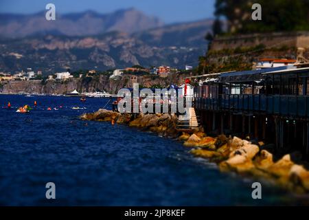 Un Beach club costiero privato vicino a Marina Grande a Sorrento nel sud Italia con i monti Lattari e la penisola sorrentina sullo sfondo. Foto Stock