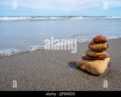 Pietre equilibrate sulla spiaggia di sabbia Foto Stock