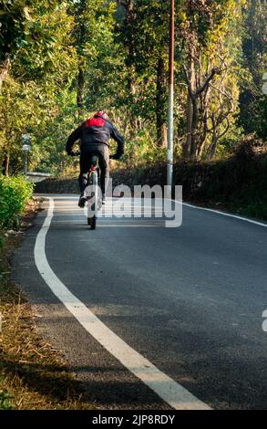 Febbraio 13th 2022. Dehradun, Uttarakhand, India. Un ciclista con zaino in giro per le strade vuote della città di dehradun in India al mattino. Foto Stock