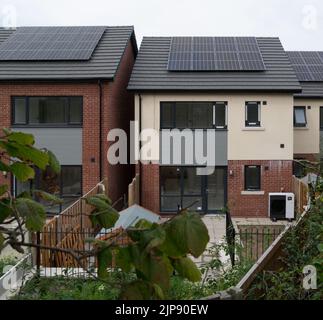 Case di nuova costruzione con pannelli solari sul tetto e unità di pompa di calore fonte d'aria installata per l'elettricità a basso costo riducendo le bollette di energia del Galles del Nord Foto Stock