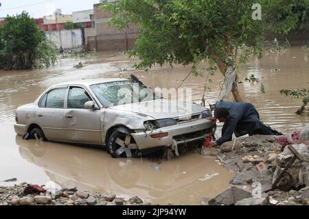 Nangarhar, Afghanistan. 15th ago, 2022. Un uomo controlla un'auto distrutta da un'alluvione nella provincia di Nangarhar, Afghanistan, 15 agosto 2022. Almeno otto persone sono state uccise e altre sei sono state ferite lunedì a causa di forti piogge e inondazioni improvvise nella provincia orientale afghana di Nangarhar, ha dichiarato un funzionario locale. Credit: Aimal Zahir/Xinhua/Alamy Live News Foto Stock