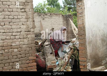 Nangarhar, Afghanistan. 15th ago, 2022. Una donna è vista in una casa distrutta da un'alluvione nella provincia di Nangarhar, Afghanistan, 15 agosto 2022. Almeno otto persone sono state uccise e altre sei sono state ferite lunedì a causa di forti piogge e inondazioni improvvise nella provincia orientale afghana di Nangarhar, ha dichiarato un funzionario locale. Credit: Aimal Zahir/Xinhua/Alamy Live News Foto Stock