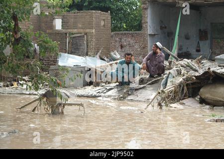 Nangarhar, Afghanistan. 15th ago, 2022. Le persone sono viste nella zona colpita dalle inondazioni nella provincia di Nangarhar, Afghanistan, 15 agosto 2022. Almeno otto persone sono state uccise e altre sei sono state ferite lunedì a causa di forti piogge e inondazioni improvvise nella provincia orientale afghana di Nangarhar, ha dichiarato un funzionario locale. Credit: Aimal Zahir/Xinhua/Alamy Live News Foto Stock