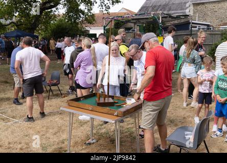 Village fete England - un uomo anziano che gioca una partita di birilli bar, Burton Bradstock annuale villaggio fete, Dorset UK Foto Stock