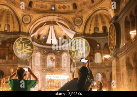 Viaggio a Istanbul foto di sfondo. Un uomo e una donna che scattano foto di Hagia Sophia o della moschea di Ayasofya. Istanbul Turchia - 8.12.2022 Foto Stock