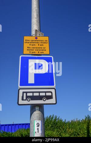 Rhyl, Regno Unito: 11 agosto 2022: La segnaletica indica un posto per il parcheggio di autobus e pullman. Un cartello bilingue spiega le restrizioni per le roulotte e le roulotte a motore. Foto Stock