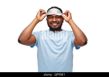 felice uomo afroamericano con maschera di sonno occhio Foto Stock