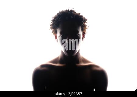 silhouette di un uomo africano muscoloso che si posa in uno studio fotografico su sfondo bianco senza un ritratto da vicino della t-shirt Foto Stock
