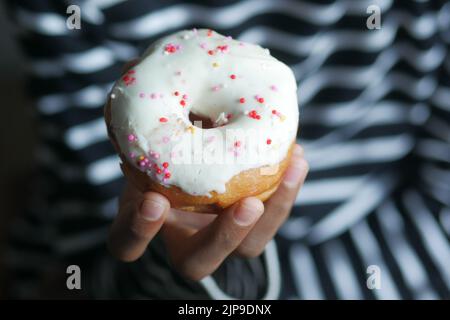 Primo piano di ciambelle di tenuta a mano . Foto Stock