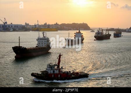 Porto di Kaohsiung (高雄港), il più grande porto di Taiwan, con cargo, navi militari, banchine e rimorchiatori Foto Stock