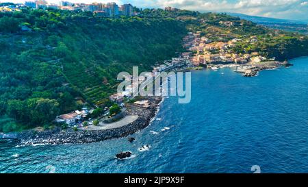 Vista aerea dall'alto della Timpa di Acireale sul villaggio di Santa Maria la Scala con mare e cielo azzurro - Sicilia Foto Stock