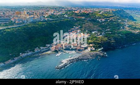 Vista aerea dall'alto della Timpa di Acireale sul villaggio di Santa Maria la Scala con mare e cielo azzurro - Sicilia Foto Stock