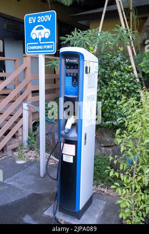 Un punto di ricarica per veicoli elettrici a 200 volt del marchio Toyota G-Station II a Kannon Onsen o sorgenti termali nel parcheggio dell'hotel con un cartello EV. Foto Stock