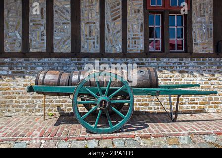 Carrello a mano antico caricato con vecchi barili / barili di legno per il trasporto della birra Foto Stock